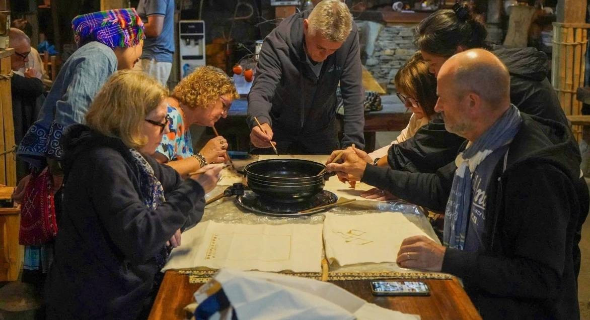 Les visiteurs découvrent la technique de dessin à la cire d’abeille sur tissu. Photo: VOV