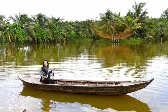 Des visiteurs expérimentent la navigation en pirogue de bois. Photo : vnexpress.net