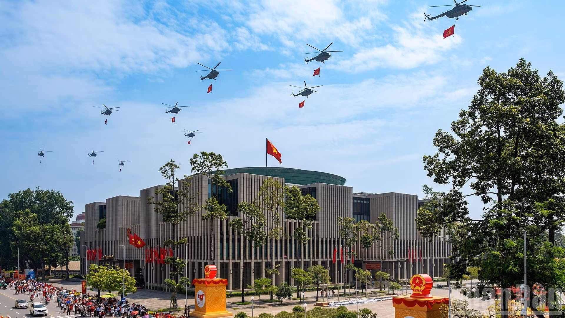 Une formation de dix hélicoptères arborant le drapeau du Parti et le drapeau national survolent la place Ba Dinh. Photo : Giang Huy.