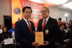 Hoang Phuc Lam, professeur associé et docteur, directeur adjoint de l’Académie nationale de politique Ho Chi Minh remet le livre à un membre du Parti du Travail du Mexique. Photo : VNA.