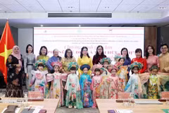 Des délégués et des enfants participent à un défilé de l'"áo dài". Photo : VNA.