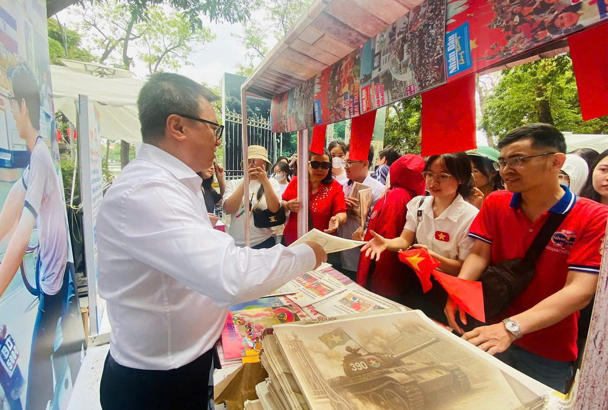 Le Quoc Minh, rédacteur en chef du Journal Nhân Dân, remet aux lecteurs les premiers exemplaires du supplément spécial. Photo : NDEL. phu-san-6.png