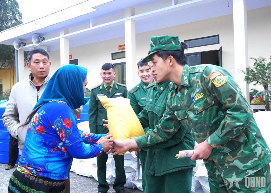 Sourire aux lèvres, les soldats remettent avec attention les cadeaux du Têt aux habitants. Photo : QĐND. 
