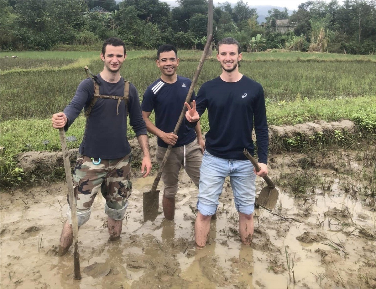 Des visiteurs étrangers participent à des activités agricoles aux côtés de Vien Dang Phu (au centre). Photo : baovanhoa. vien-dang-phu-du-khach-trai-nghiem-lam-nong-nghiep-baodantoc.jpg