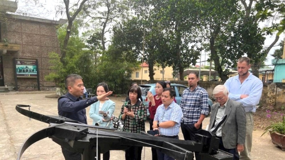 L’ingénieur Vu Dinh Thanh (chemise noire) présente la conception de l’« arbalète magique » reconstituée. Photo : NDEL. vu-dinh-thanh-no-than.jpg