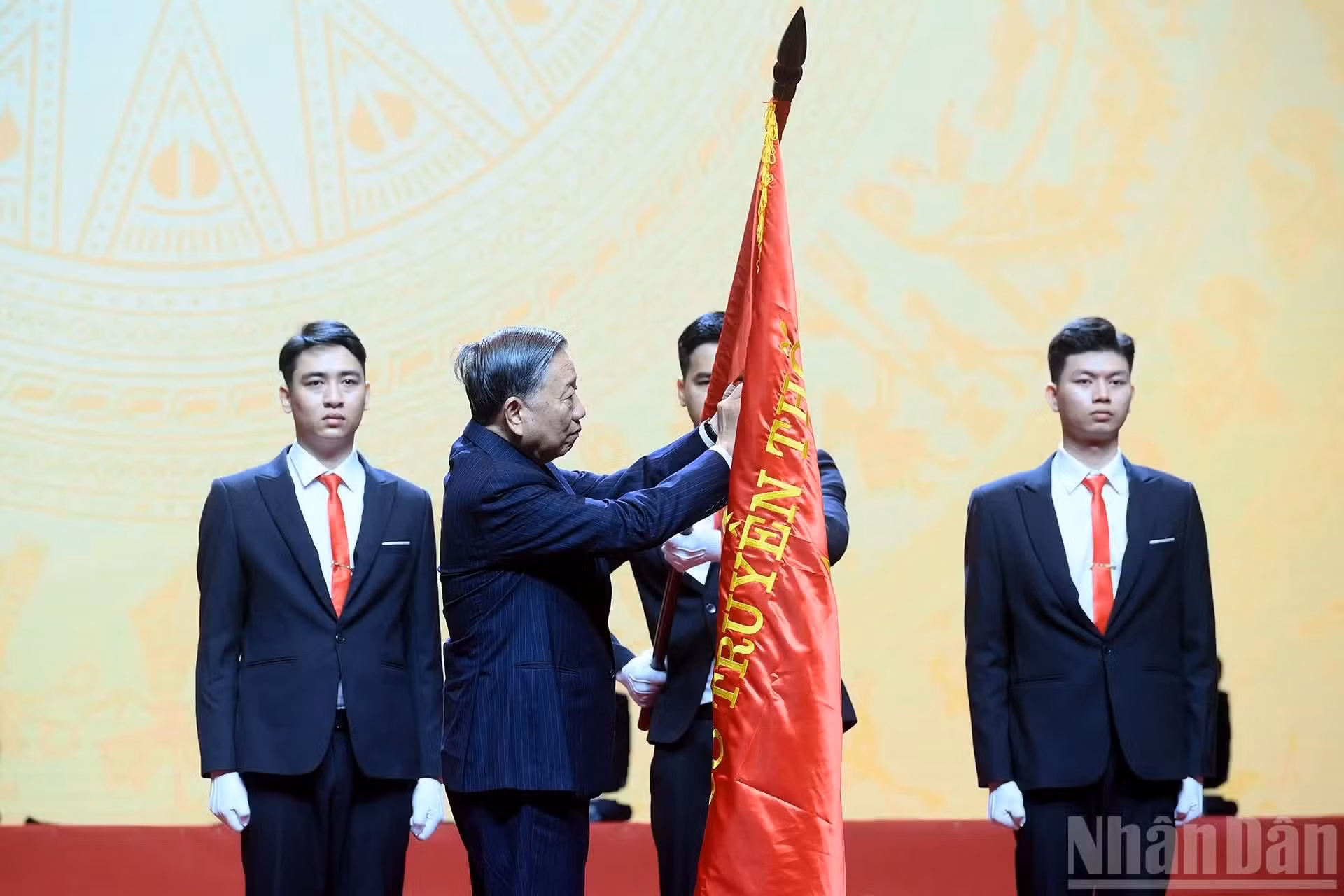 Le secrétaire général et président To Lam appose l’Ordre du Travail de première classe sur le drapeau traditionnel de l’Université nationale de Hanoï.