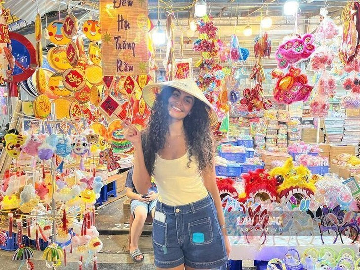 Une touriste israélienne achète lanternes et chapeaux coniques pour ses proches. Photo : laodong. 9-anh3-dukhachnuocngoai-ukkb.jpg