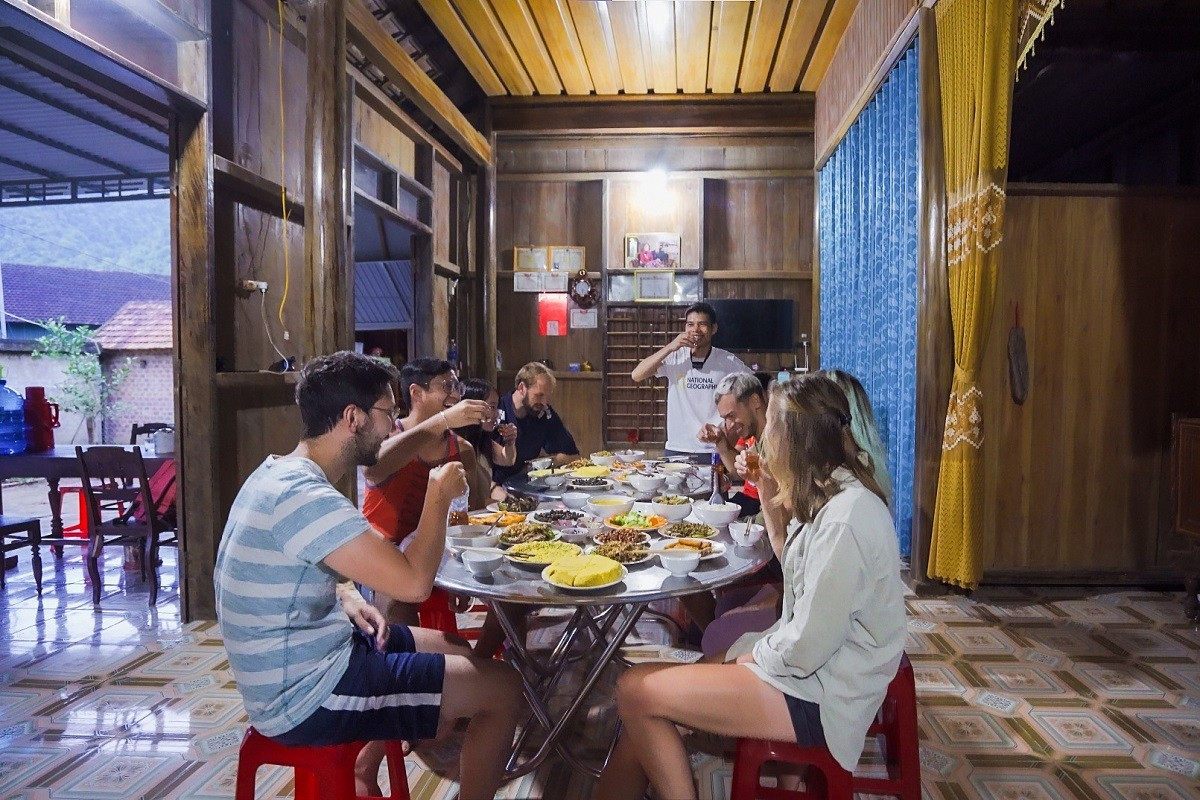 Des touristes étrangers prennent leurs repas chez l'habitant du village de Tan Hoa. Photo : laodong. touristes-village-tan-hoa-ld.jpg
