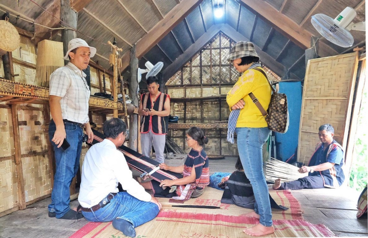 Des visiteurs découvrent les métiers traditionnels des Ba Na au village de Stor. Photo : baogialai. stor-metiers.jpg