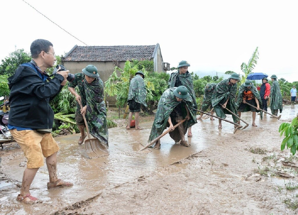 Un journaliste en reportage après les inondations dans le hameau de Kha La (commune de Tan Lap, district de Luc Ngan, province de Bac Giang). Photo : VNA. pv-hien-truong-2.jpg