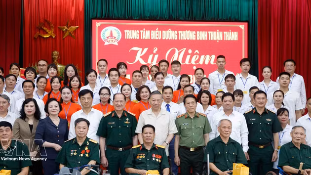 Le secrétaire général du Parti et président vietnamien, To Lam, et les délégués aux côtés du personnel et des anciens militaires blessés ou atteints de graves séquelles pris en charge au Centre de Thuan Thanh. Photo : VNA. 