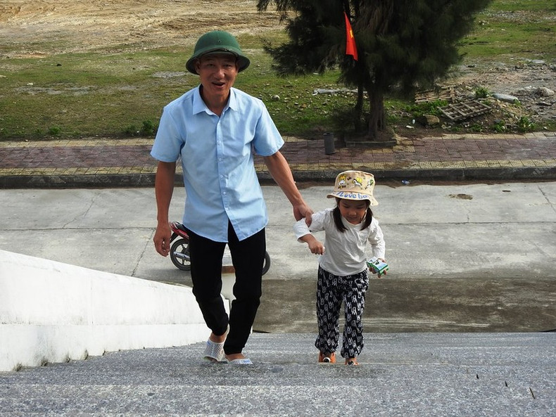 Très tôt, un parent amène son enfant à l’école pour assister à la cérémonie d’ouverture.