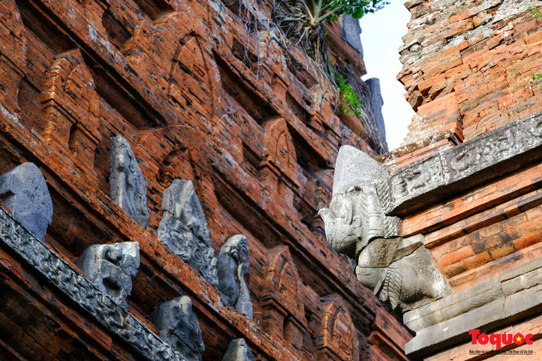 Chaque niveau est marqué aux quatre coins par des statues de Garuda, représentées avec les jambes pliées appuyées contre les coins et les bras tendus semblant soutenir le poids des niveaux supérieurs. Malgré une exposition prolongée à l’air marin salé, les reliefs restent en excellent état.