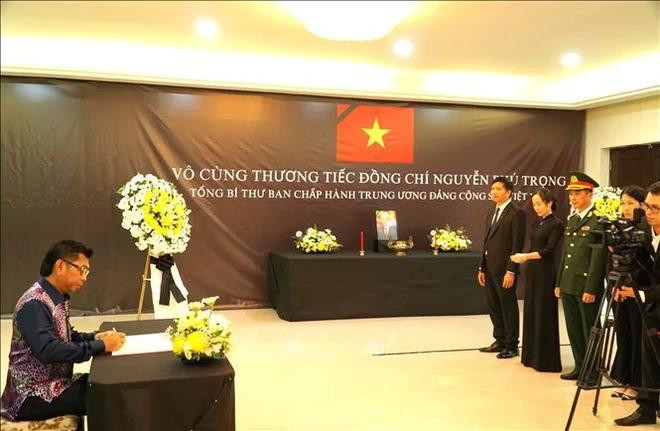 Le vice-ministre malaisien des Affaires étrangères Mohamad Alamin écrit son message dans le registre de condoléances. Photo : VNA. Le vice-ministre malaisien des Affaires étrangères Mohamad Alamin écrit son message dans le registre de condoléances. Photo : VNA.