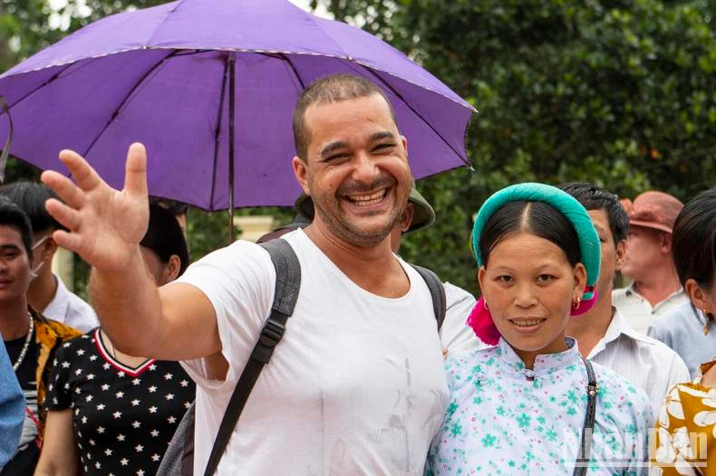 Un touriste étranger participe avec enthousiasme aux activités culturelles avec la population locale. Un touriste étranger participe avec enthousiasme aux activités culturelles avec la population locale.