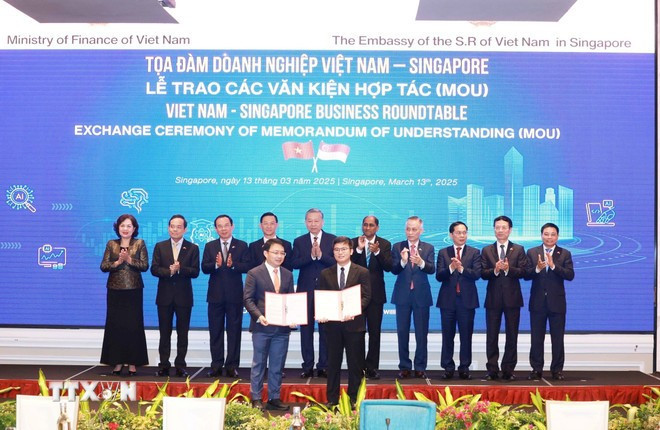 Le secrétaire général Tô Lâm (5e de gauche à droite) assiste à l'échange de documents de coopération entre les entreprises des deux pays. Photo : VNA. Le secrétaire général Tô Lâm (5e de gauche à droite) assiste à l'échange de documents de coopération entre les entreprises des deux pays. Photo : VNA.