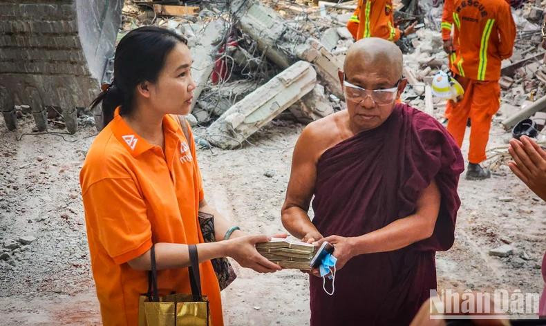 Mme Chu Thi Nguyet offre des cadeaux et de l'argent aux moines et aux personnes touchées par le tremblement de terre à Sagaing, la localité la plus gravement dévastée. Photo : NDEL.