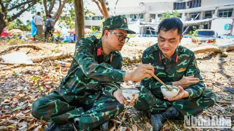 Deux sauveteurs de l'Armée populaire du Vietnam prennent le déjeuner afin de se préparer pour le quart de l'après-midi. Photo : Thanh Dat/NDEL.