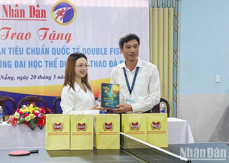 Le représentant de la Société par actions de culture et d’apprentissage du Vietnam remet des livres à l’Université d’éducation physique et sportive de Da Nang. Photo : NDEL