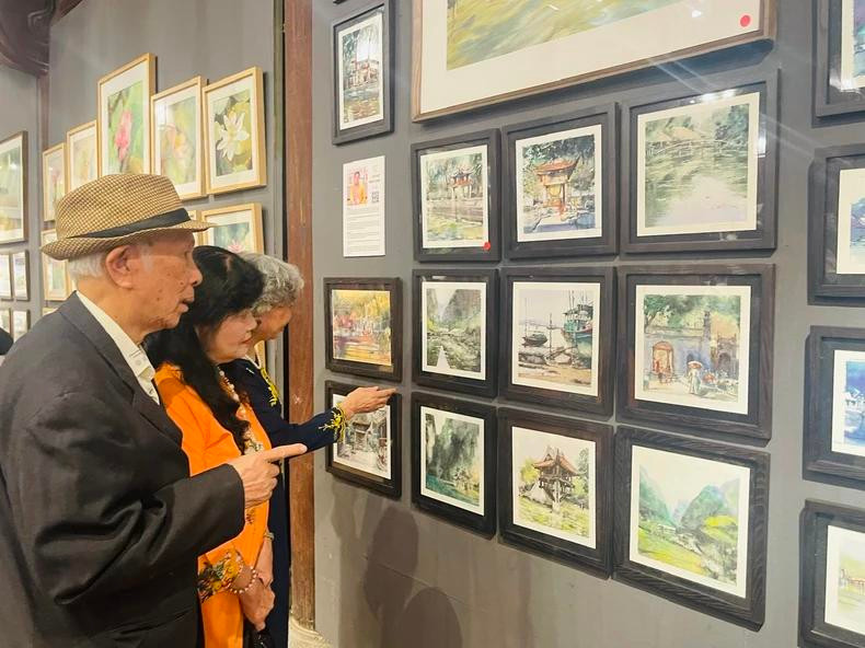 Le public est impressionné par la série de peintures représentant des sites emblématiques du Vietnam, réalisées à l'aquarelle et à l'encre par l’artiste Minh Dàm, l’un des artistes de renommée internationale et cofondateur de l’Association des Aquarellistes de Pologne. Photo: NDEL. Le public est impressionné par la série de peintures représentant des sites emblématiques du Vietnam, réalisées à l'aquarelle et à l'encre par l’artiste Minh Dàm, l’un des artistes de renommée internationale et cofondateur de l’Association des Aquarellistes de Pologne. Photo: NDEL.