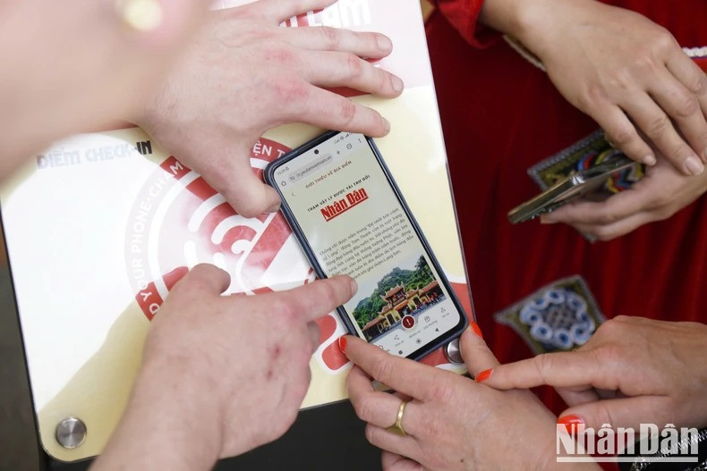 Les visiteurs consultent les présentations des sites touristiques sur le système "Yêu lắm Việt Nam" du Journal Nhân Dân. Photo : NDEL. Les visiteurs consultent les présentations des sites touristiques sur le système "Yêu lắm Việt Nam" du Journal Nhân Dân. Photo : NDEL.