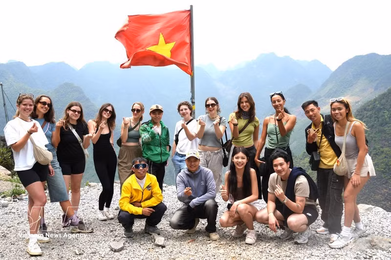 Un groupe de touristes internationaux pose pour une photo-souvenir sur le plateau karstique de Dong Van. Photo : VNA.
