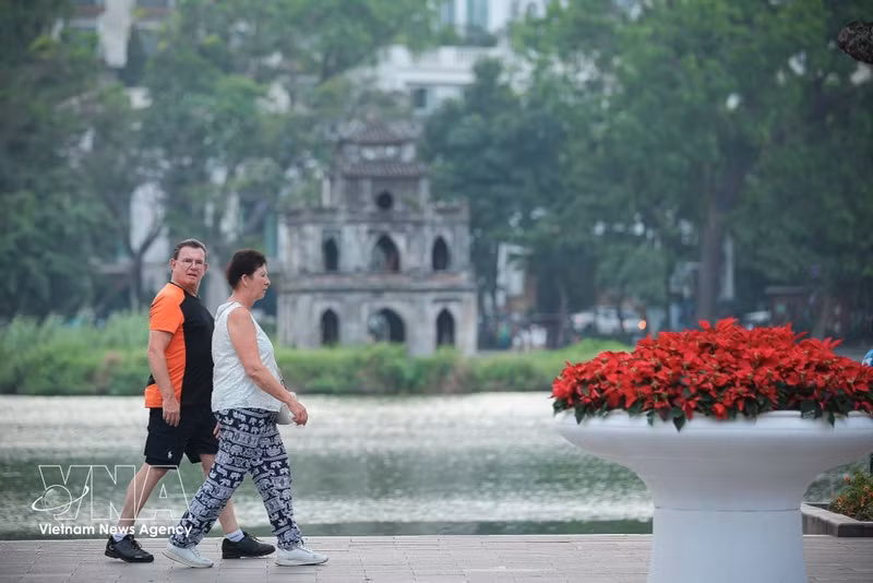 Des touristes se promènent autour du lac Hoan Kiem, à Hanoï. Photo : VNA.