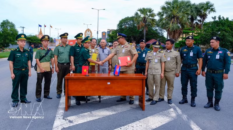 Des représentants des forces compétentes vietnamiennes et cambodgiennes coordonnent les procédures d’accueil des ressortissants vietnamiens au poste frontalier international de Binh Hiep. Photo : VNA.