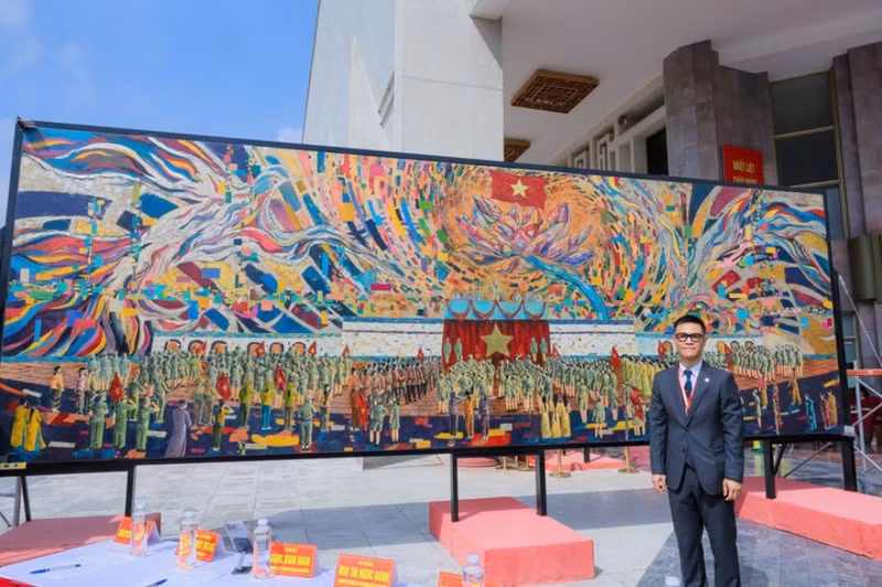 Le peintre Chu Nhat Quang à côté de la peinture sur laque grand format, sans assemblage, « l’Oncle Hô lit la Déclaration d'indépendance ». Photo : NDEL.