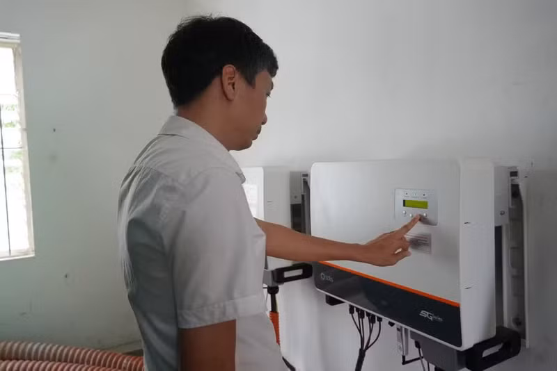 Un technicien de la compagnie d'électricité de Lao Cai effectue une inspection périodique des paramètres de fonctionnement de l’onduleur d’un système photovoltaïque installé au siège de l’entreprise. Photo : NDEL.