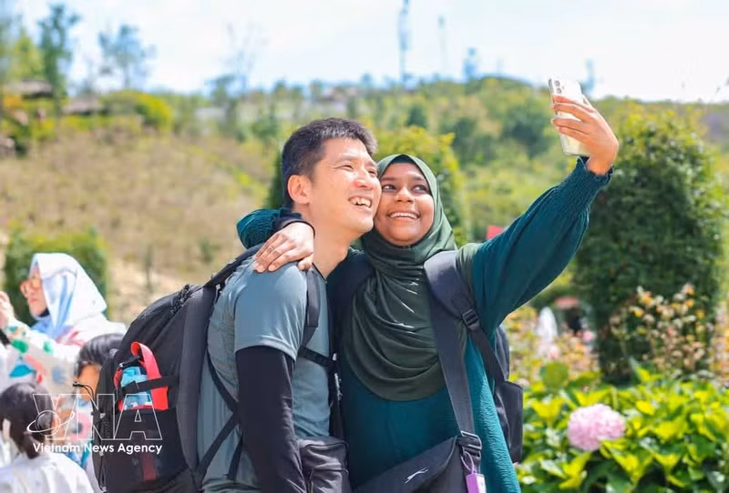 Des touristes immortalisent leur ascension au sommet du Fansipan. Photo : VNA.