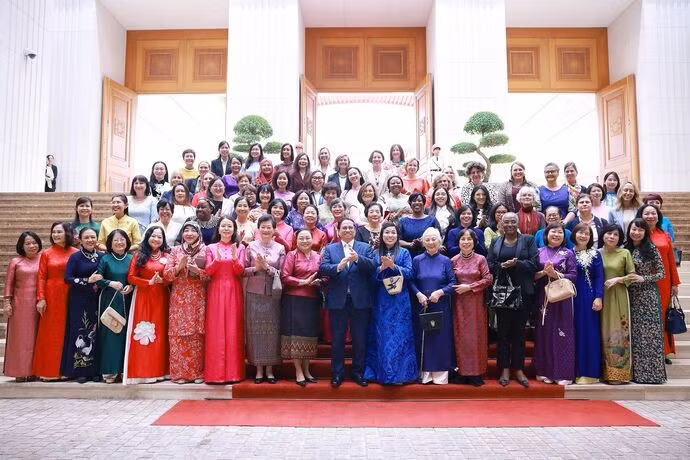 Le Premier ministre vietnamien Pham Minh Chinh et son épouse (en "ao dai" bleu) rencontrent à Hanoi des femmes diplomates vietnamiennes et étrangères en poste au Vietnam. Photo : VNA.