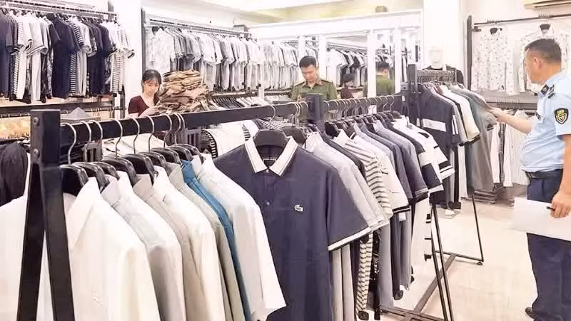 Les autorités procèdent à l’inspection d’une boutique de mode vendant des produits contrefaits de grandes marques internationales dans le quartier de Tay Tuu, à Hanoï. Photo : NDEL.