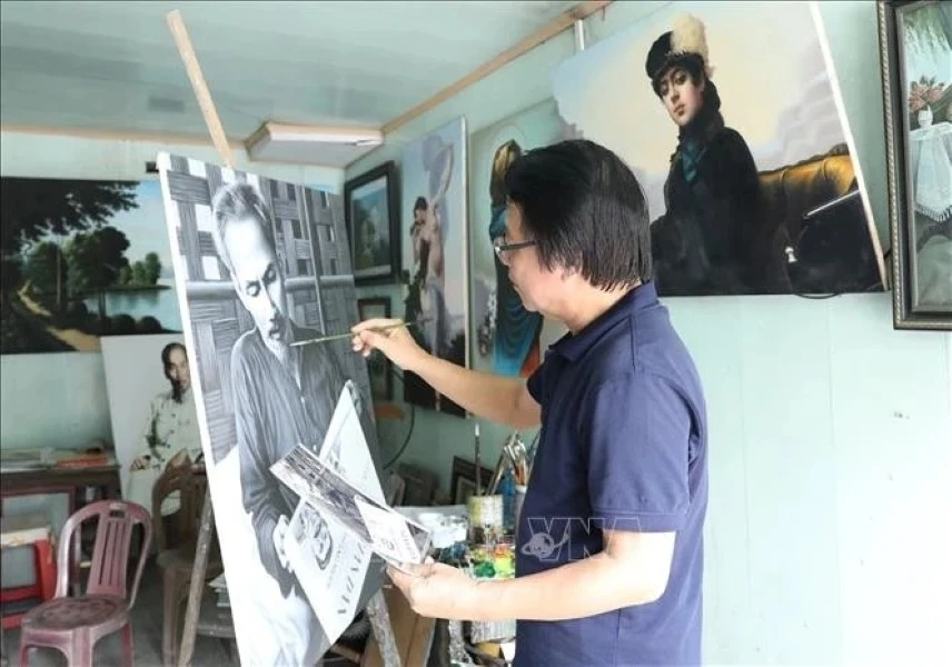 L'artiste Tran Hoa Binh peint le portrait de l'Oncle Ho. Photo : VNA.