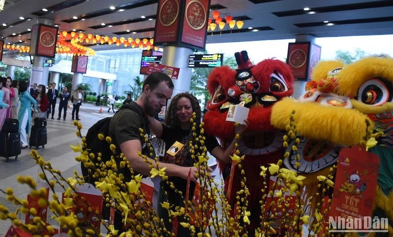 Les touristes sont ravis de participer au tirage au sort dès leur arrivée à l’aéroport international de Dà Nang le matin du premier jour du Têt.