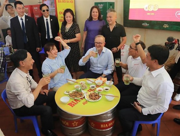 Le Premier ministre australien déguste le « bánh mì » vietnamien et la bière traditionnelle de Hanoï. Photo : VNA. Le Premier ministre australien déguste le « bánh mì » vietnamien et la bière traditionnelle de Hanoï. Photo : VNA.