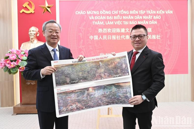 Le camarade Lê Quôc Minh présente au camarade Chen Jianwen le supplément illustré en panorama sur la Campagne de Diên Biên Phu. Le camarade Lê Quôc Minh présente au camarade Chen Jianwen le supplément illustré en panorama sur la Campagne de Diên Biên Phu.
