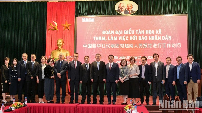 Le rédacteur en chef adjoint du journal Nhân Dân, Quê Dinh Nguyên, la vice-directrice générale de l’Agence vietnamienne de presse, Doan Thi Tuyêt Nhung, et le rédacteur en chef adjoint de Xinhua, Ren Weidong, accompagnés des dirigeants du journal Nhân Dân et des membres de la délégation de Xinhua, posent pour une photo de groupe.