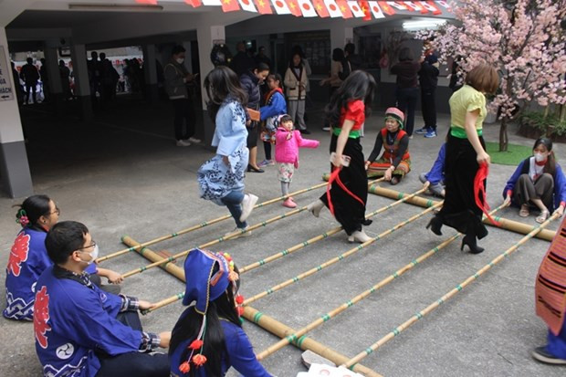 Des jeunes jouent au "nhảy sạp" (danse aux perches de bambou) lors de la fête. Photo: VOV