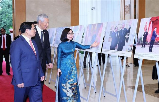 Les deux Premiers ministres ont visité une exposition de photos sur l&apos;homme et la nature du Vietnam et les relations Vietnam-Singapour. Photo : VNA.
