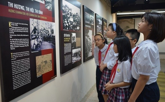 Des enfants scrutent la présentation des concours triennaux d&apos;accès au mandarinat au temple de la Littérature. Photo : qdnd.vn