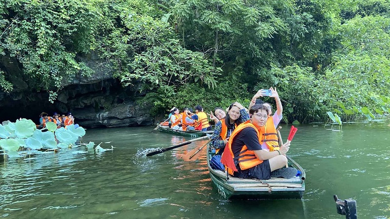 Les jeunes d'outre-mer sont ravis de contempler les paysages à Tràng An (province de Ninh Binh). Photo : baoquocte.vn