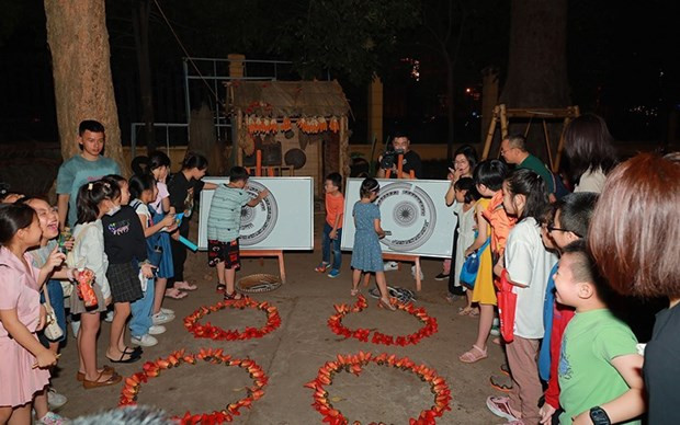 Au Musée de l'histoire du Vietnam, les enfants au son des anciens tambours de bronze. Photo: NDEL