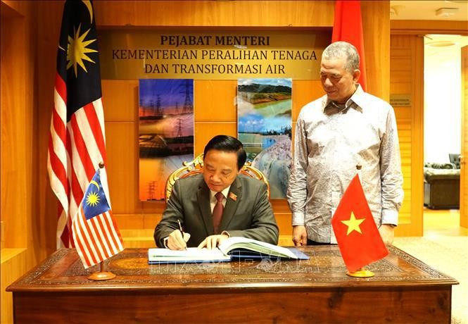 Le vice-président de l&apos;Assemblée nationale Nguyen Khac Dinh écrit dans le livre d&apos;or du bureau du vice-Premier ministre de Malaisie Haji Fadillah bin Haji Yusof. Photo : VNA.