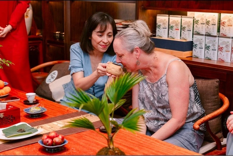 La professeure Sarah goûte le thé national parfumé au lotus.