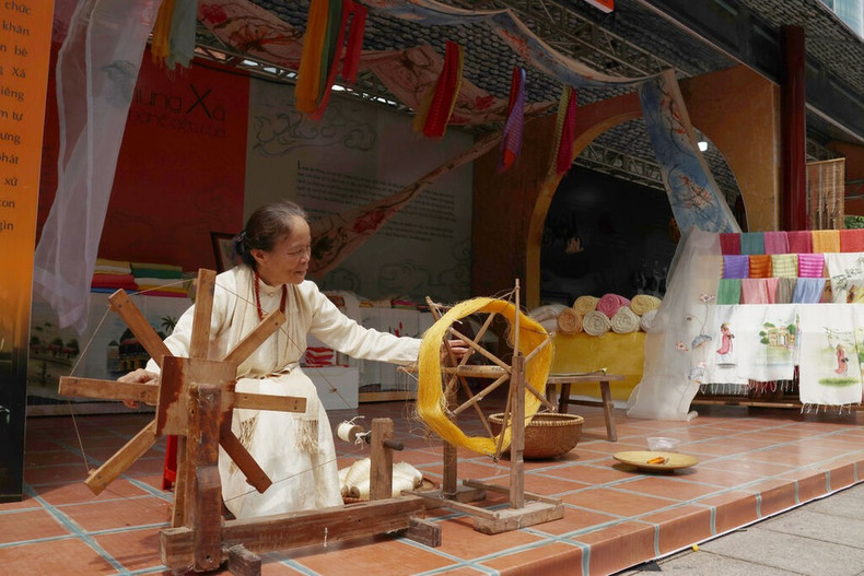 L'artsite Phan Thi Thuân (village de Phùng Xá) présente les techniques de tissage des soies issus de lotus. Photo : Quang Châu/CVN.