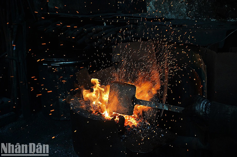 Après chaque session de forge, Hung ajoute du charbon dans le foyer pour raviver la chaleur.