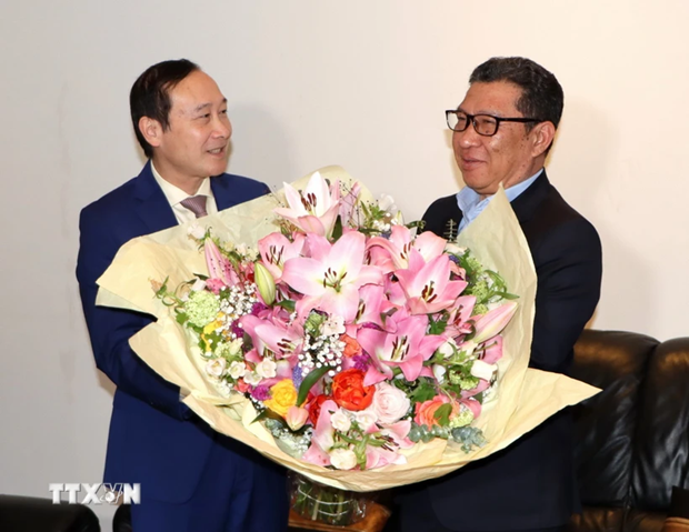 L'ambassadeur du Vietnam en Belgique, Nguyên Van Thao (à gauche), offre un bouquet de fleurs à l'ambassadeur du Laos en Belgique, Phokeo Phommahaxay. Photo : VNA.