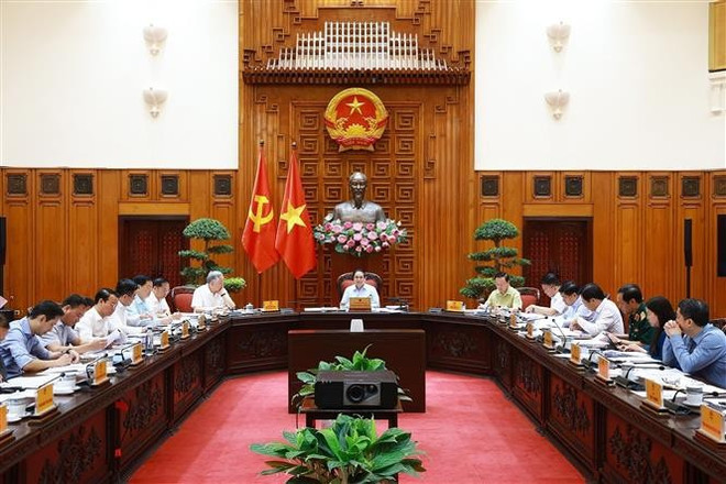 Le Premier ministre Pham Minh Chinh (centre) lors de la réunion, à Hanoi, le 22 avril. Photo : VNA.
