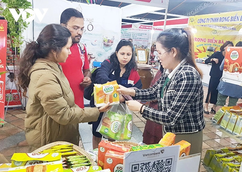 Présenter les produits OCOP à des étrangers. Photo : VOV. Présenter les produits OCOP à des étrangers. Photo : VOV.